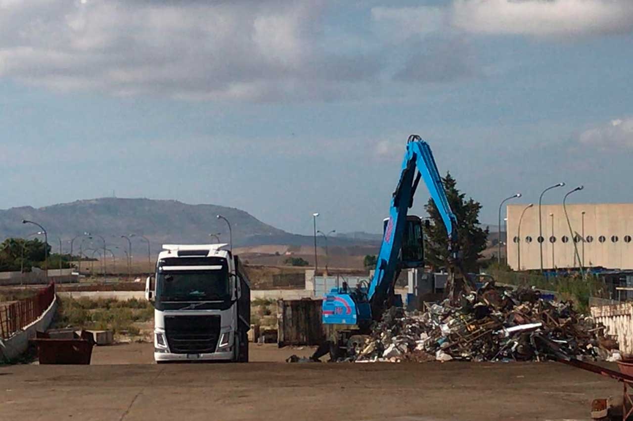 Autocarro e ragno idraulico al lavoro nel piazzale
